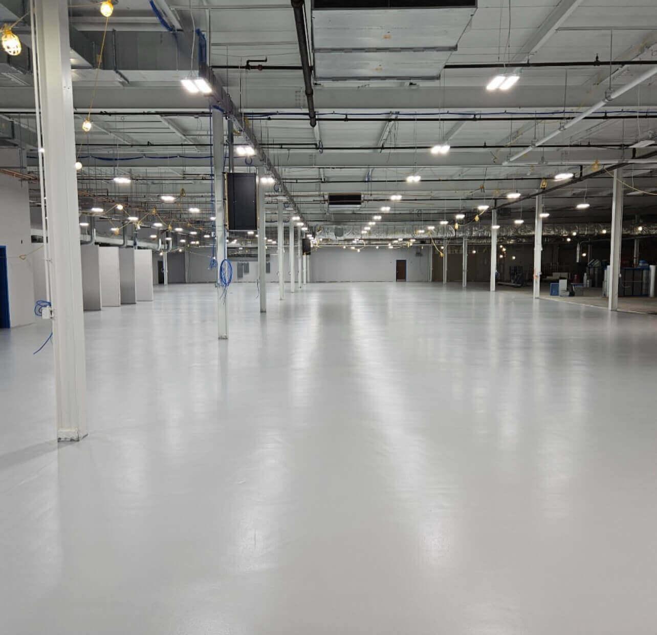 Glossy white epoxy floor in a large industrial facility