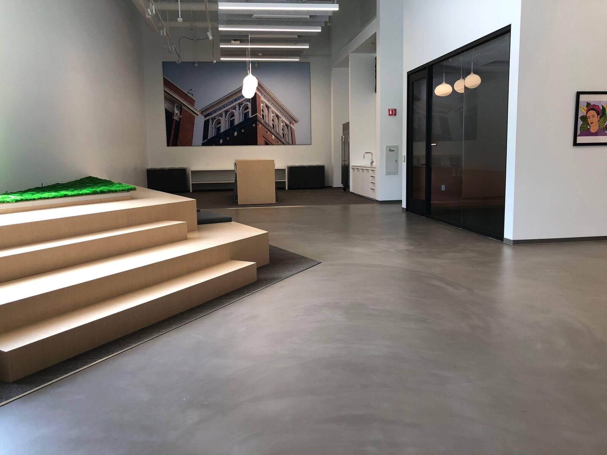 Polished concrete floor in a modern office lobby with wood steps