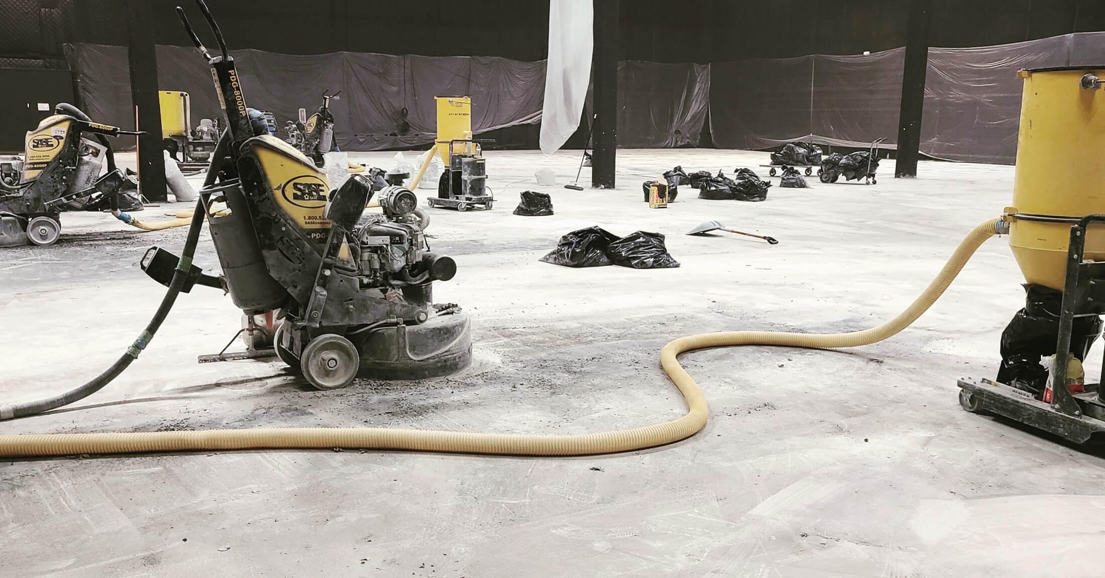 Concrete grinding equipment preparing a floor for resurfacing