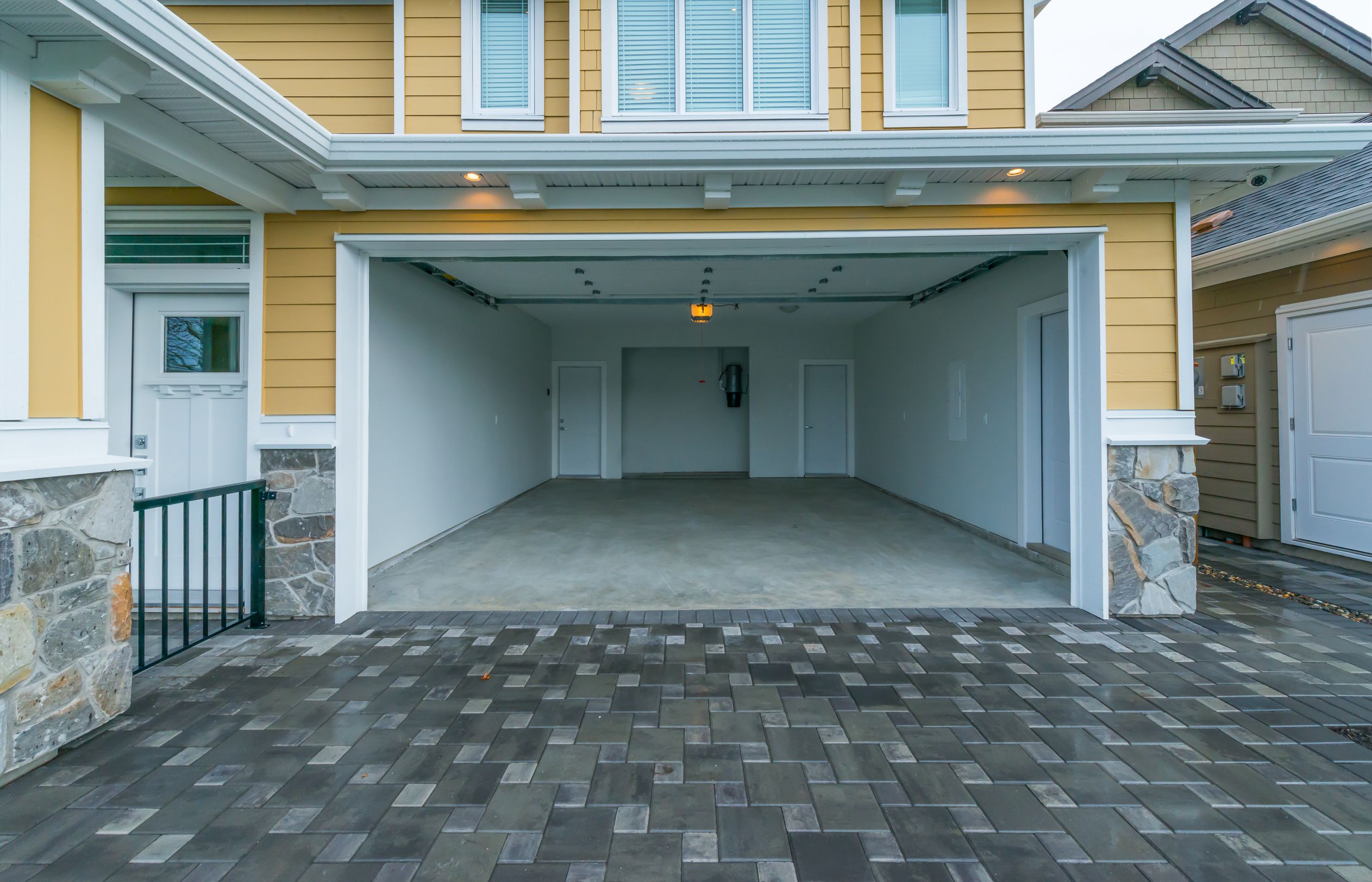 An open garage of a yellow coloured house