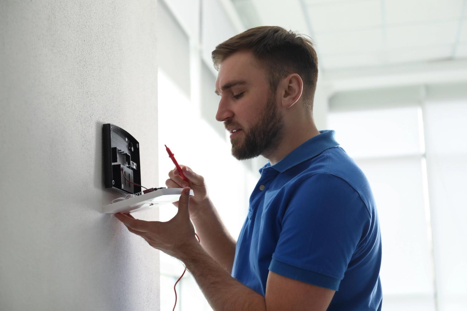 man in blue shirt installing security system