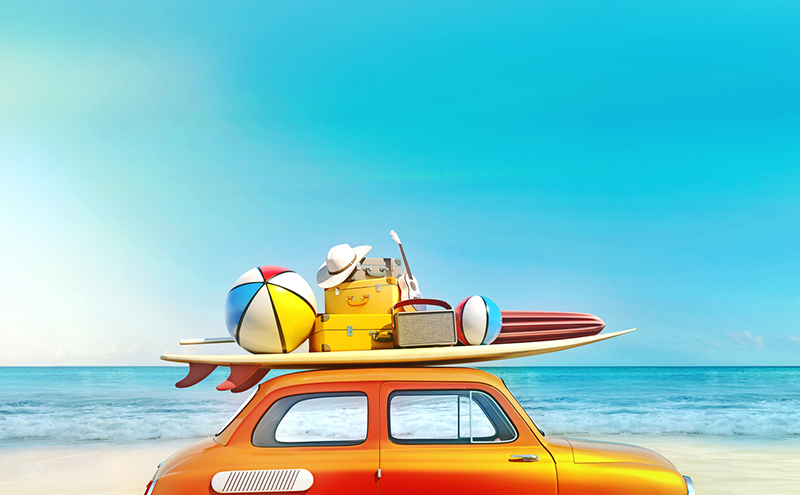 Beach items on top of a surfboard on top of a car