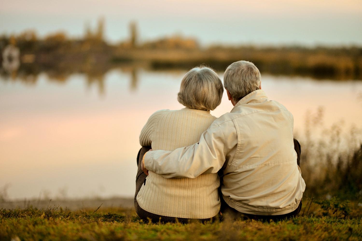 older couple hug on lake side