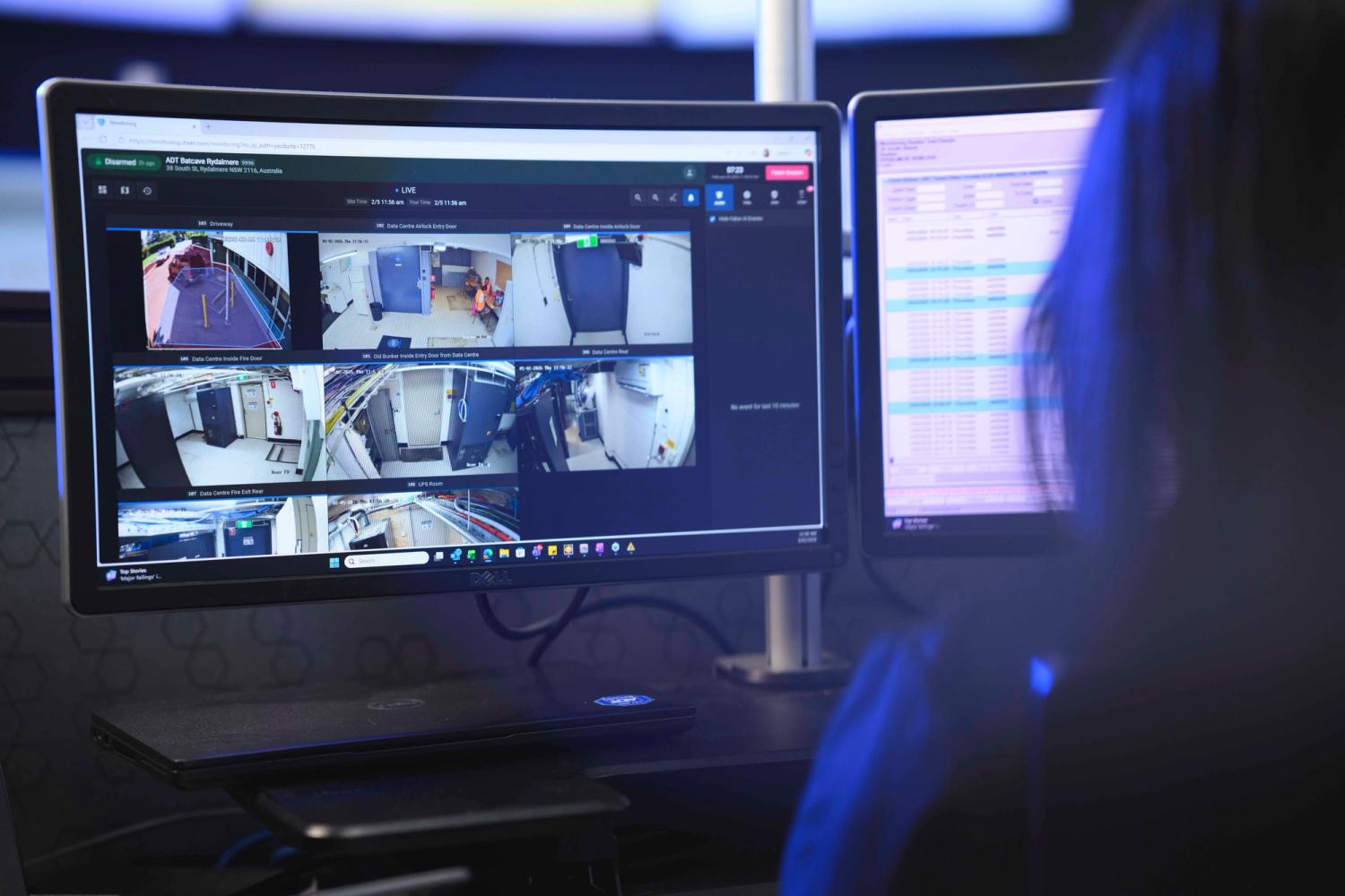 Close up of female security expert watching CCTV footage on screen.