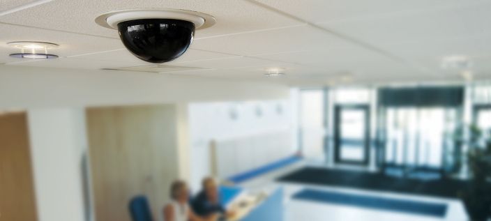 The ceiling of a room with a visibile CCTV camera