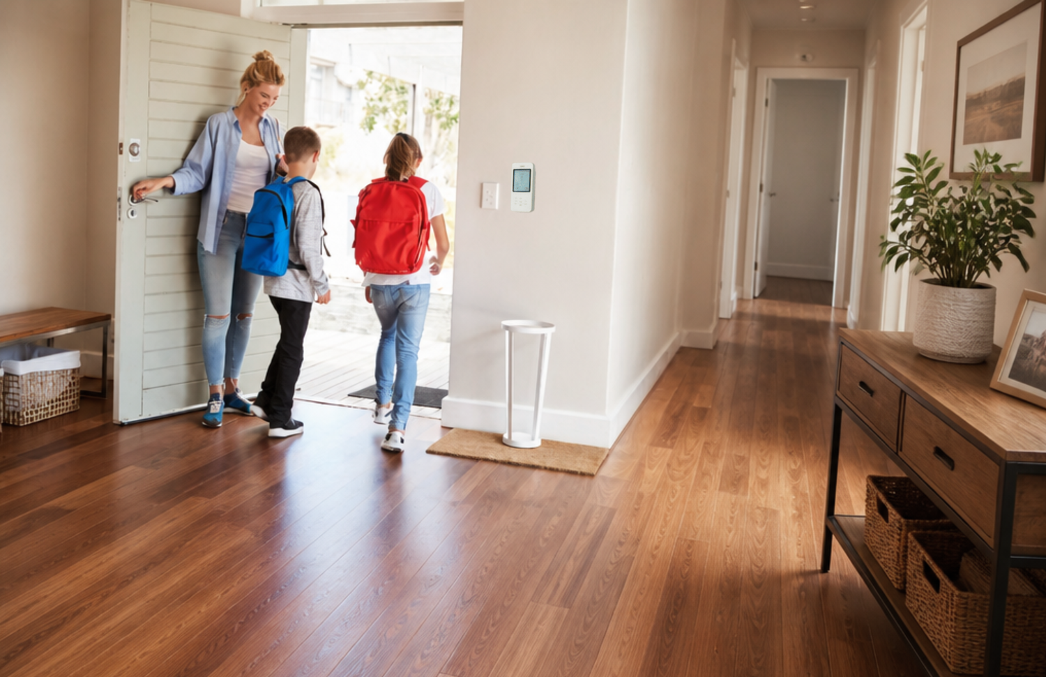 Family leaving the house with home security on the wall
