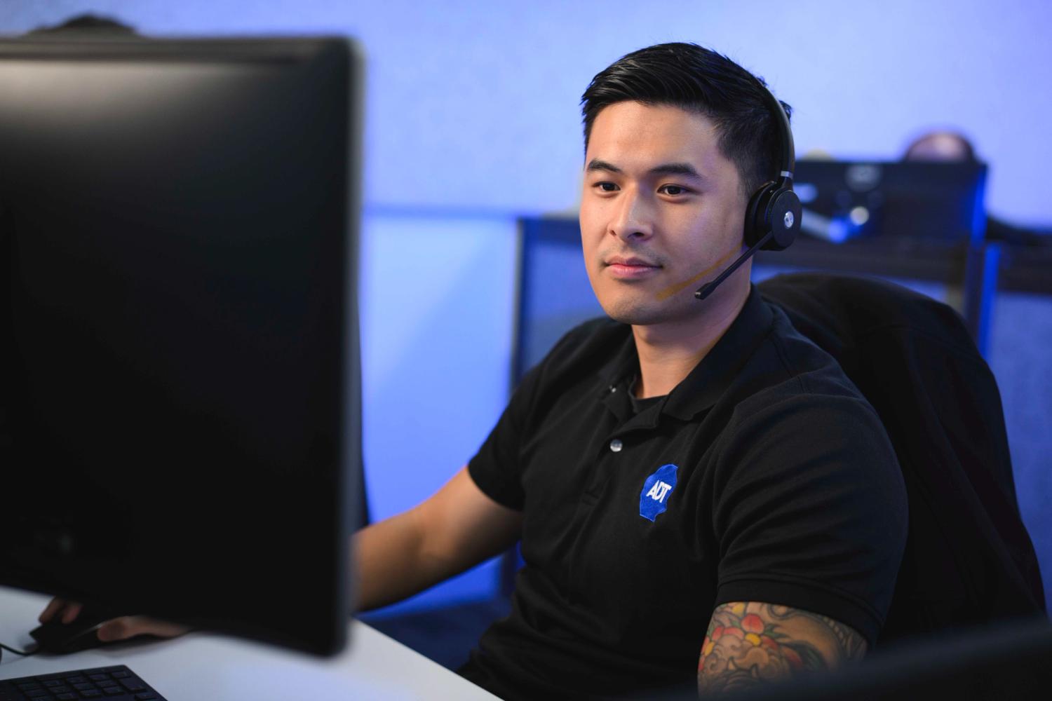 Male security monitoring professional with headset.