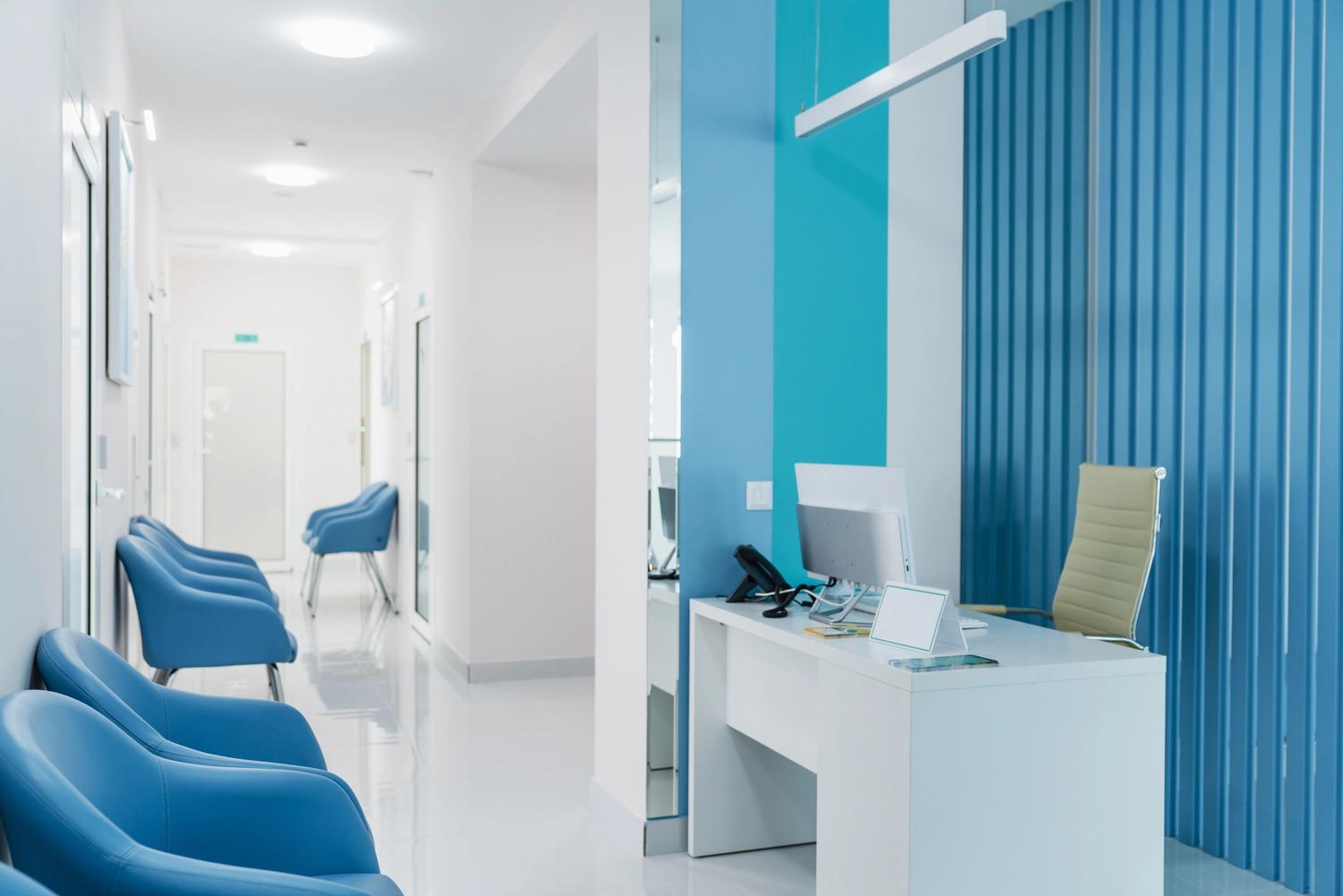 Health centre reception room with visible blue chairs for waiting customers