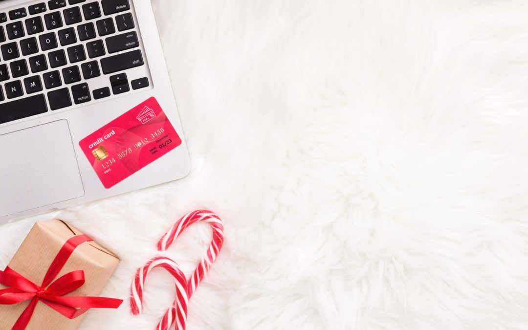 Christmas gift with laptop and credit card on white fur. Perfect presents for the holiday season.