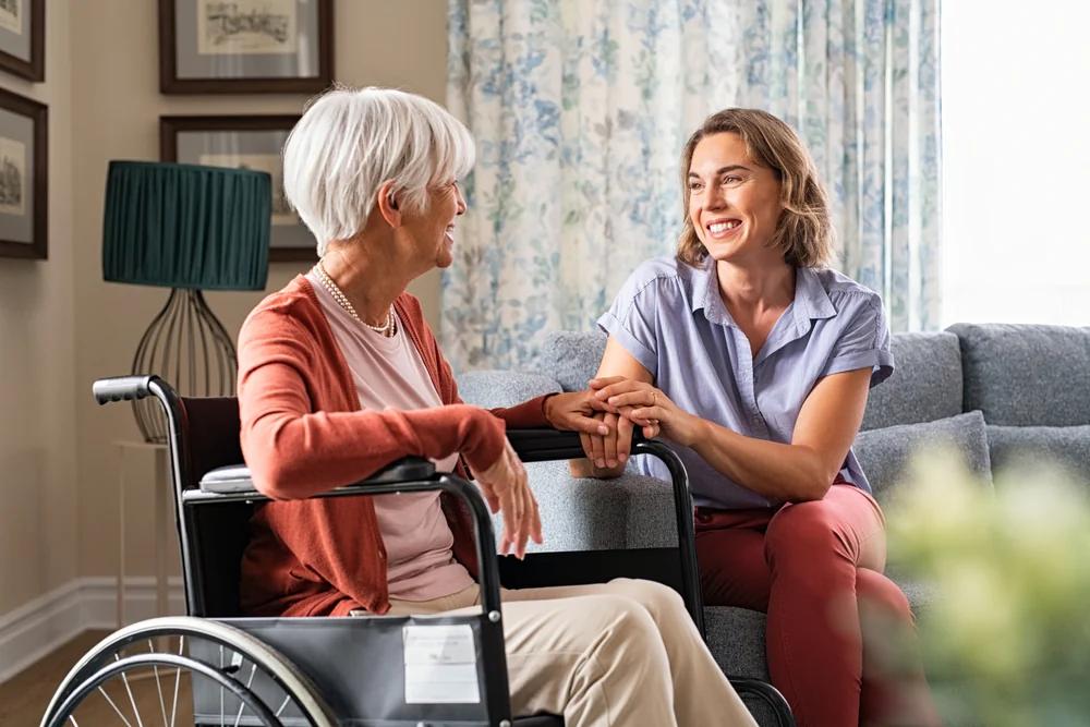 Young woman holding elderly woman's hand