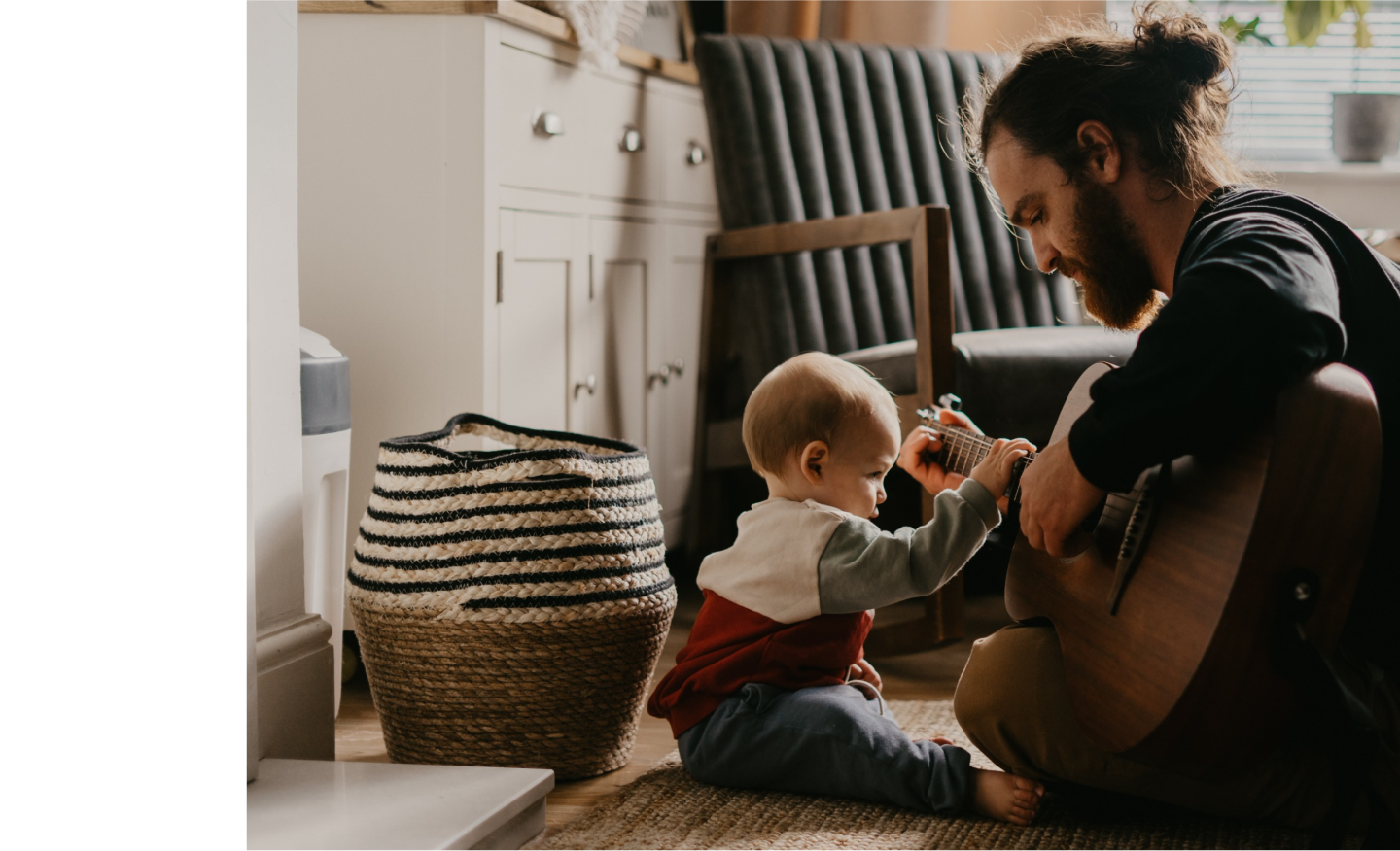 Man playing guitar to toddler child