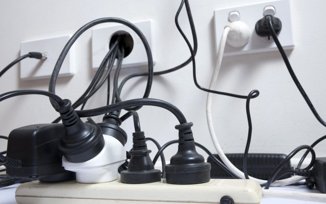 Various electrical cords and plugs connected to multple power points