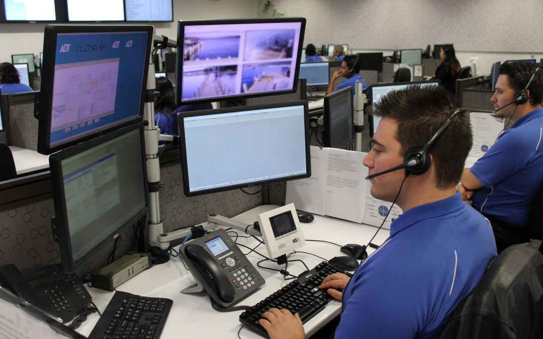 Man with headphones at his computer and four monitors