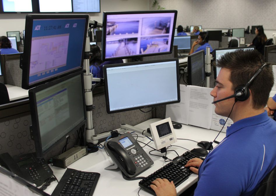Man with headphones at his computer and four monitors