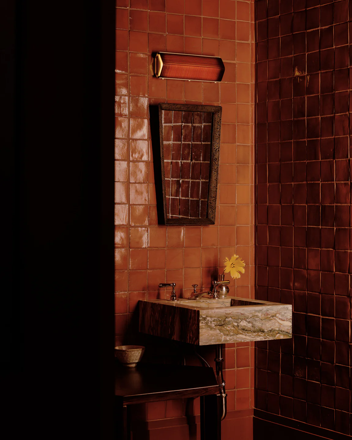 Powder room with terracotta tile walls, a marble sink and a yellow flower