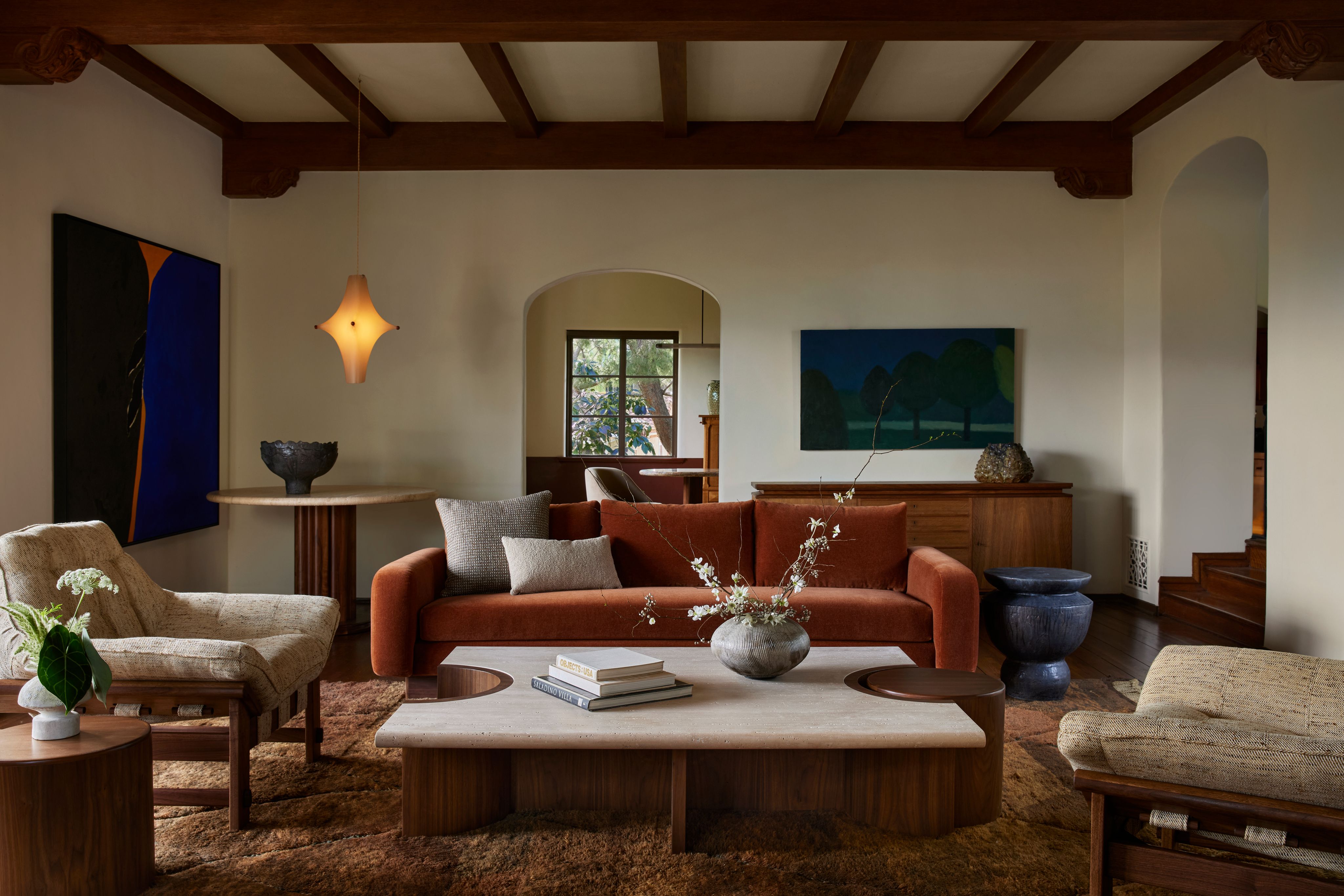 Living room with a rust velvet sofa and ceramic accents