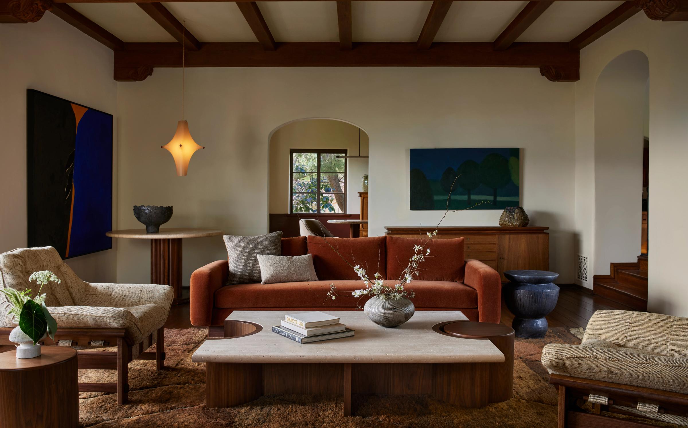 Living room with a rust velvet sofa and ceramic accents