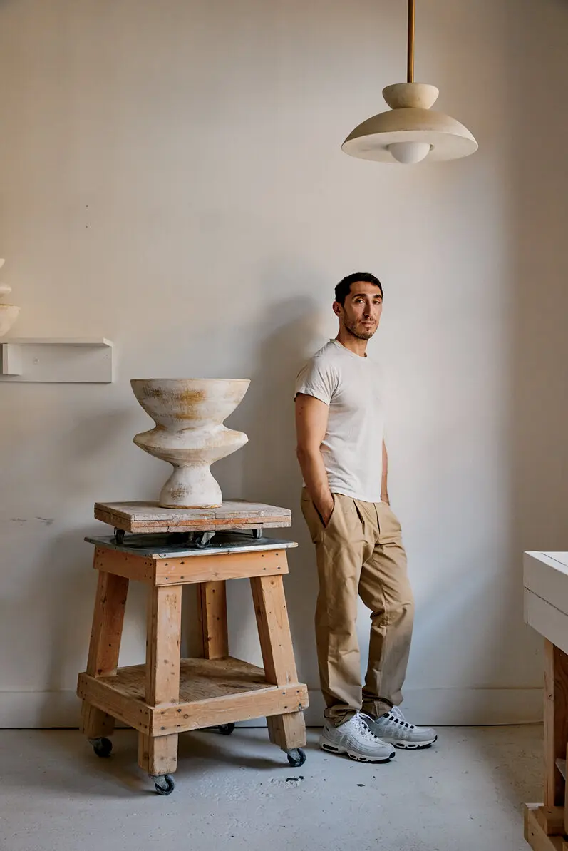 Danny Kaplan beside a ceramic vessel on a wooden work stand