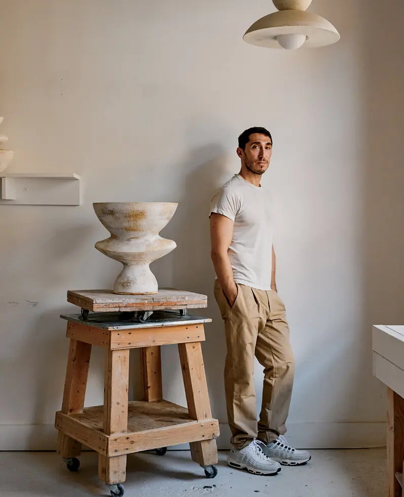 Danny Kaplan beside a ceramic vessel on a wooden work stand