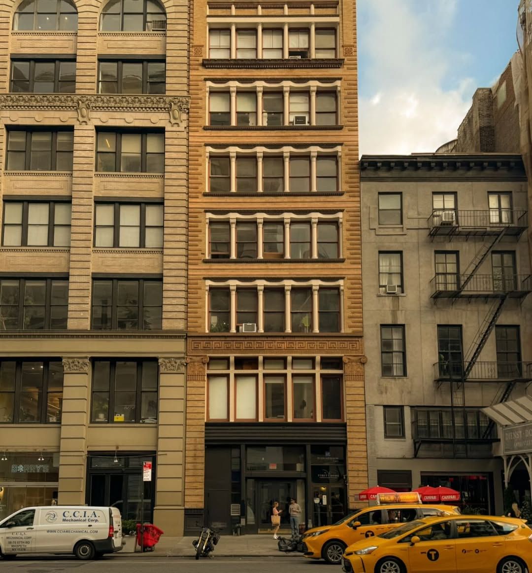 Cast-iron building facades on a New York street with yellow taxis