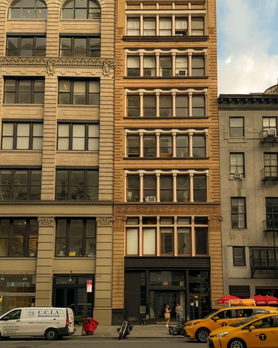 Cast-iron building facades on a New York street with yellow taxis