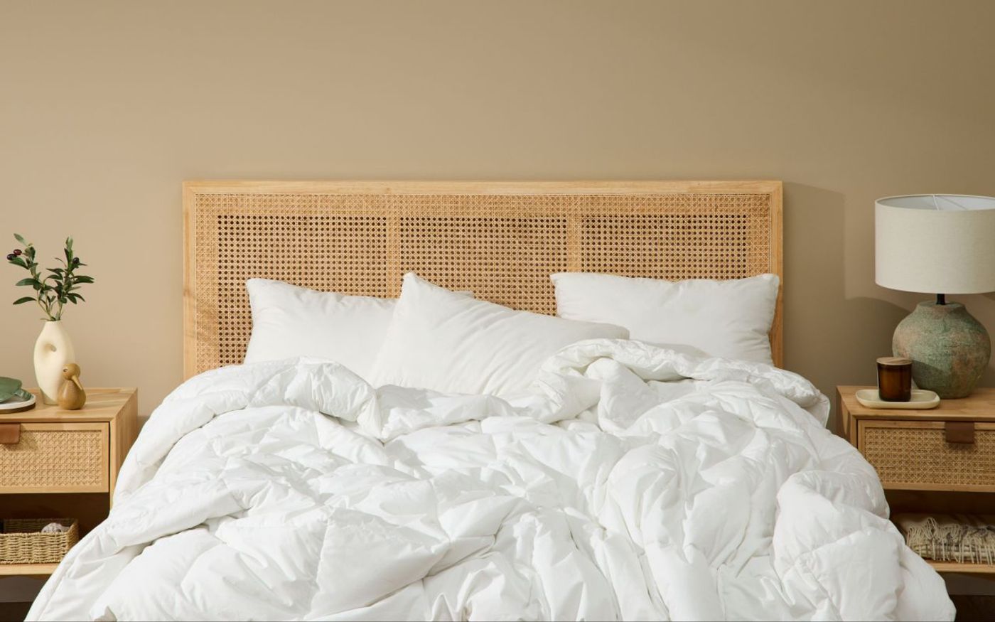 White Silk & Snow Down Alternative Duvet on a bed with a rattan headboard