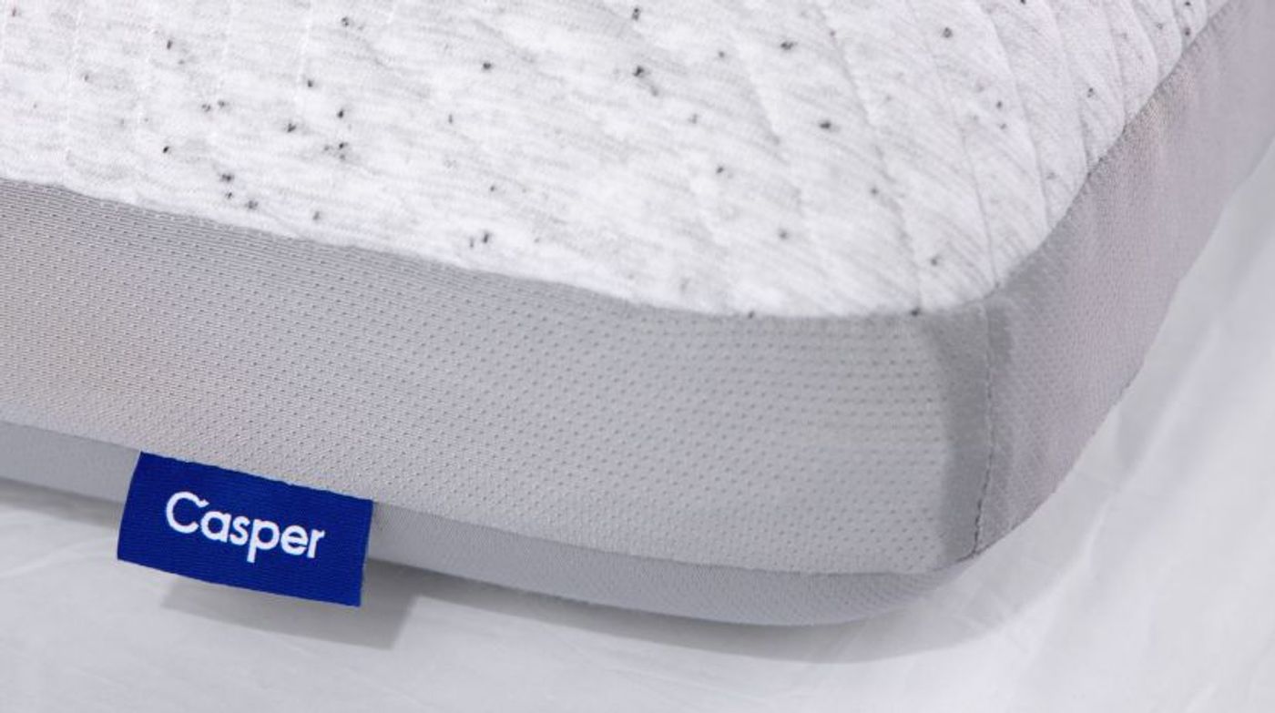 Close-up of the corner of a Casper pillow with its blue Casper label