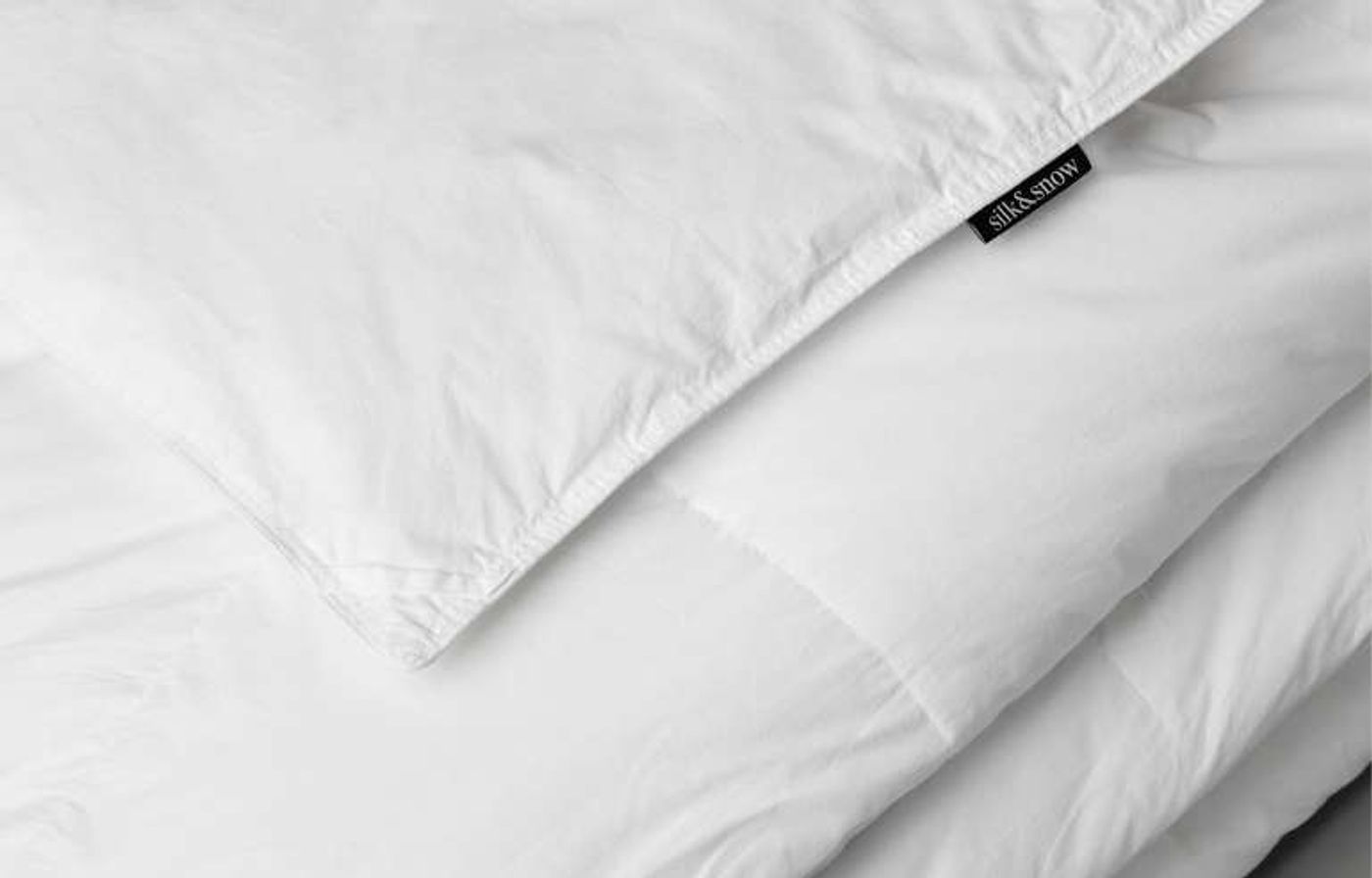 Close-up of the stitched corner and label of the Silk & Snow Down Alternative Duvet