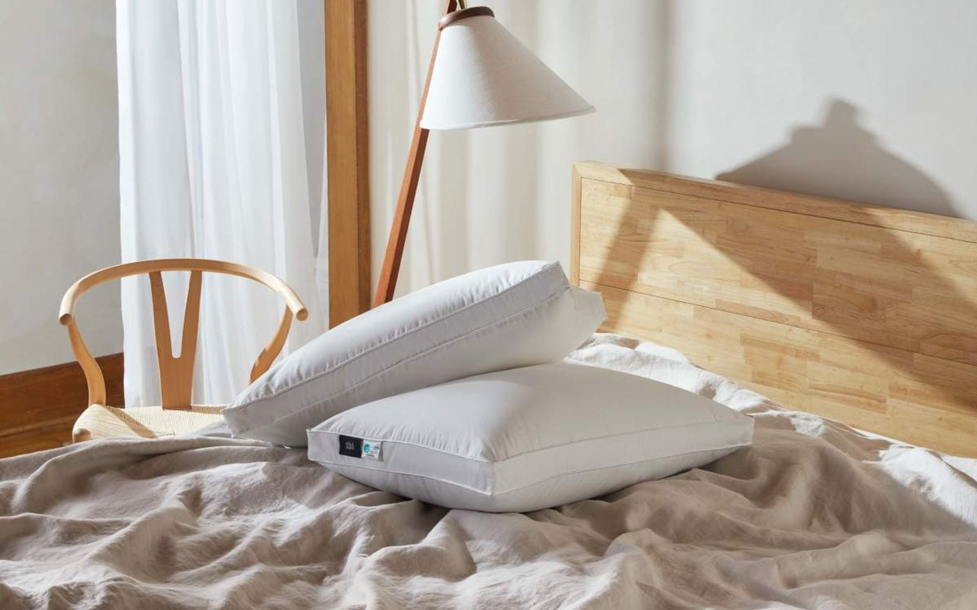 Two Silk & Snow Reserve Down Pillows on a bed in a bright bedroom