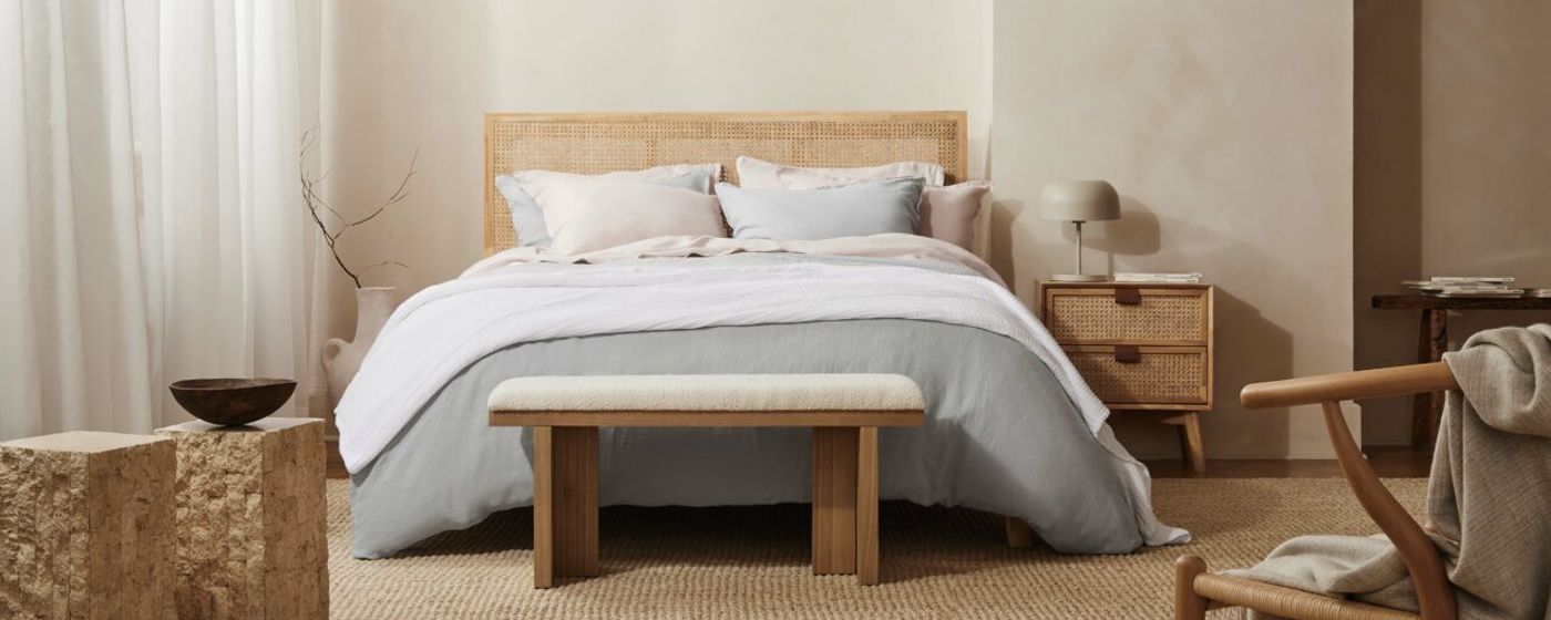 Bright bedroom with a bed made in light blue Silk & Snow flax linen sheets