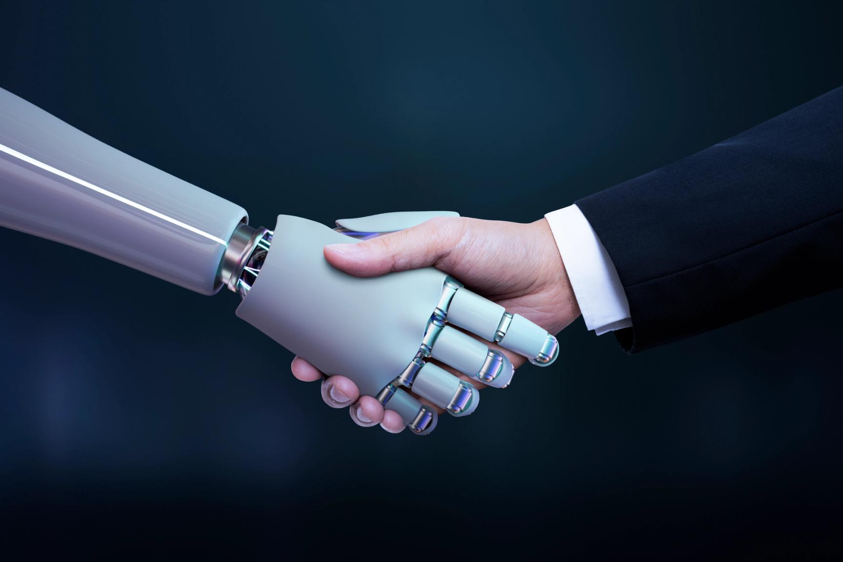 A robotic hand and a human hand in a business suit shake hands against a dark blue background, symbolizing partnership between humans and artificial intelligence or technology.
