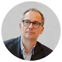 Male in glasses and black jacket and airpod in his ear.