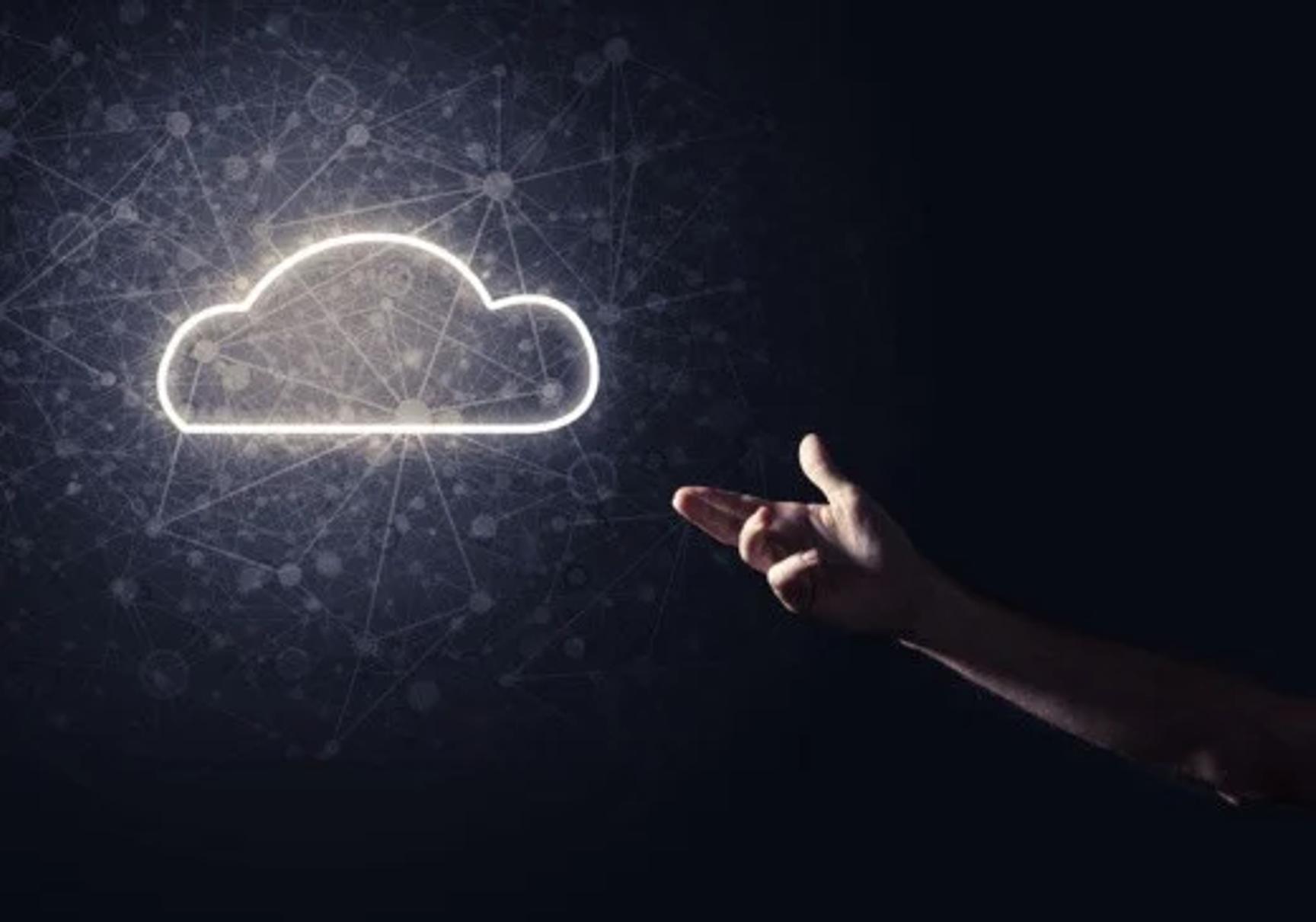 A person's hand pointing at a glowing white cloud symbol surrounded by digital network lines, dark background.