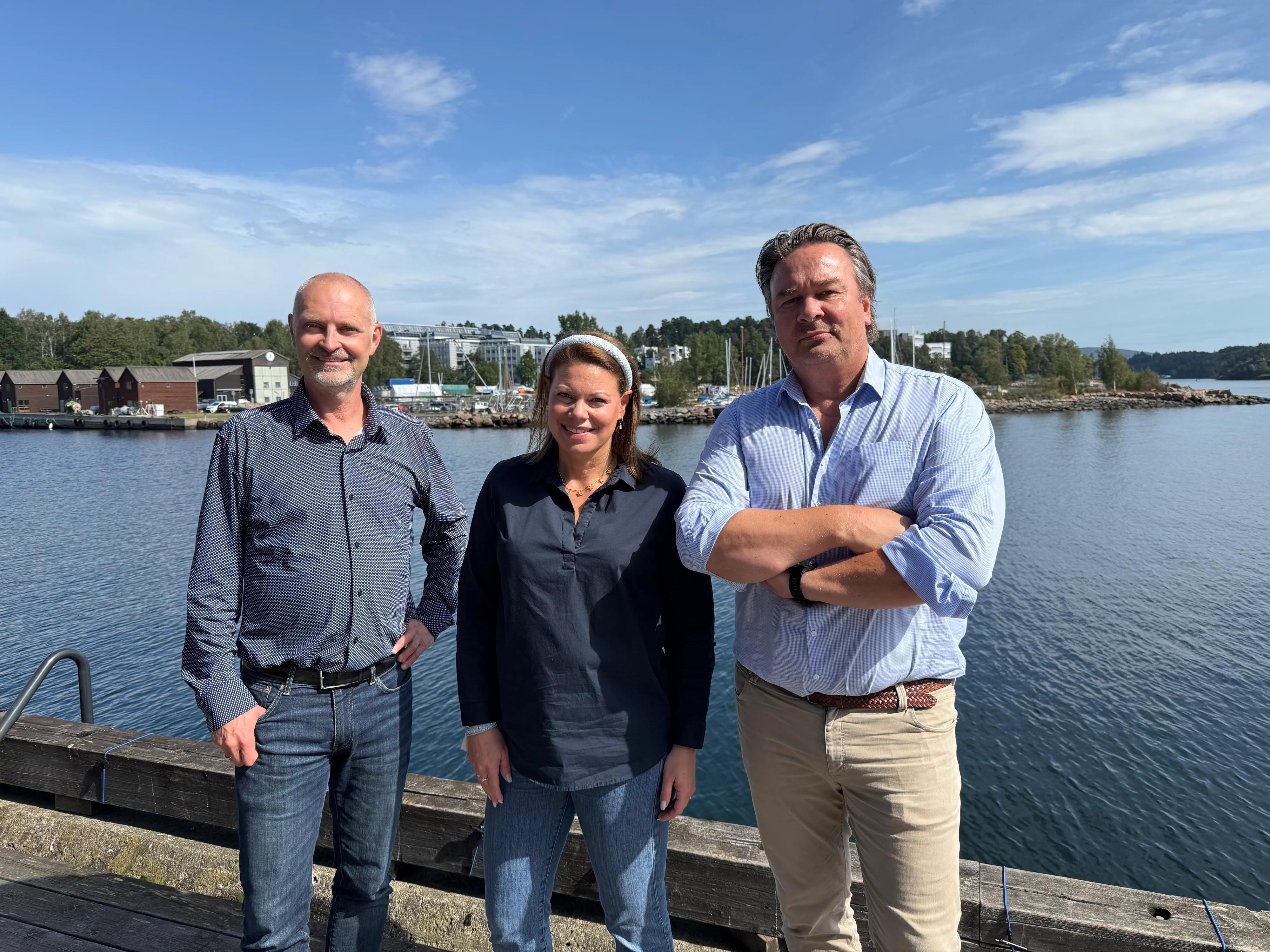 Three people standing outside in a group photo.
