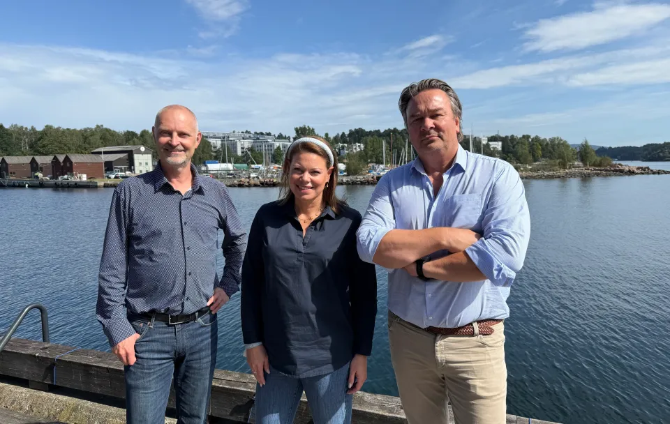 Three people standing outside in a group photo.
