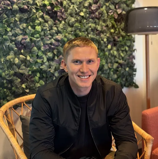 Smiling man sitting down in a chair.