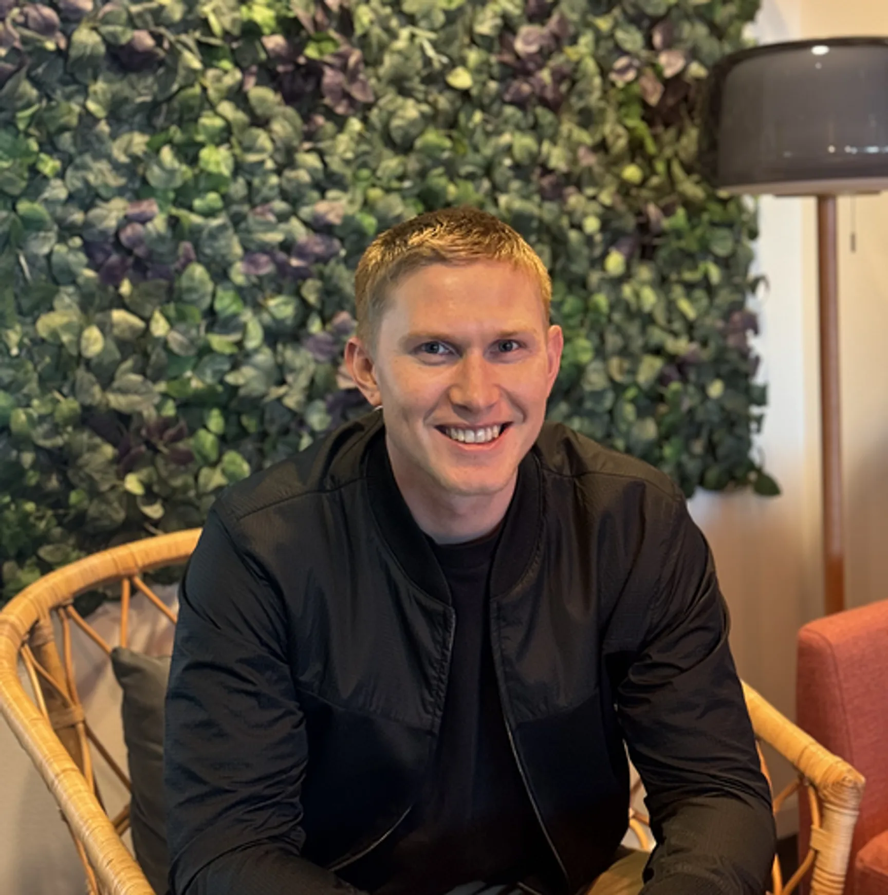 Smiling man sitting down in a chair.