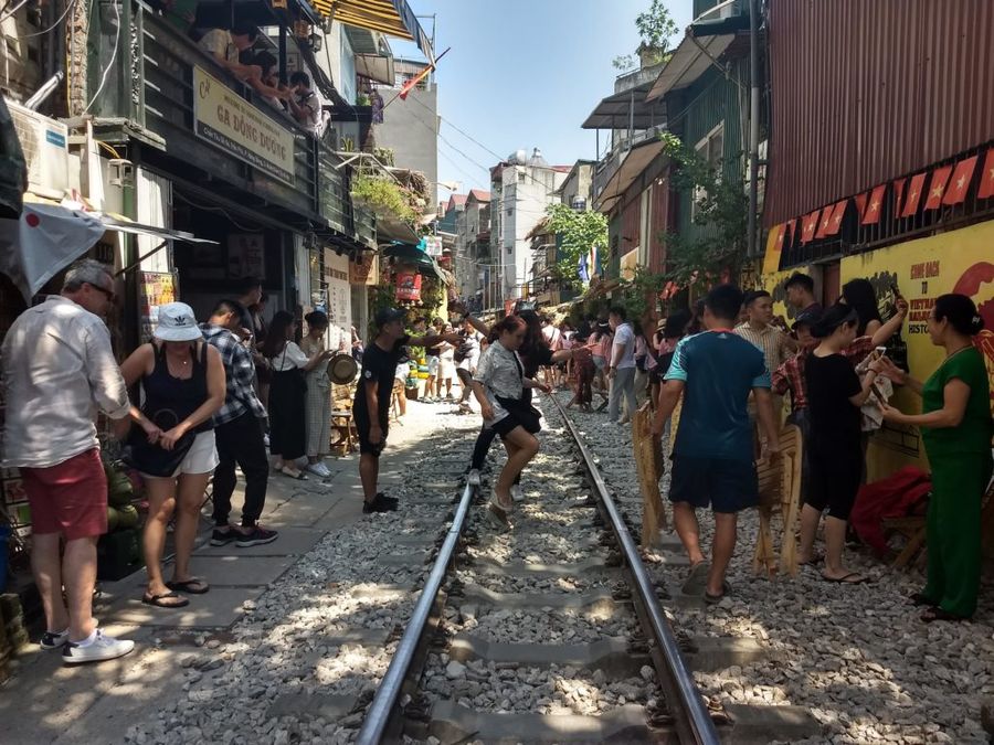 Ihned po projetí vlaku se celá Train street vrací do běžného chodu, Hanoi.