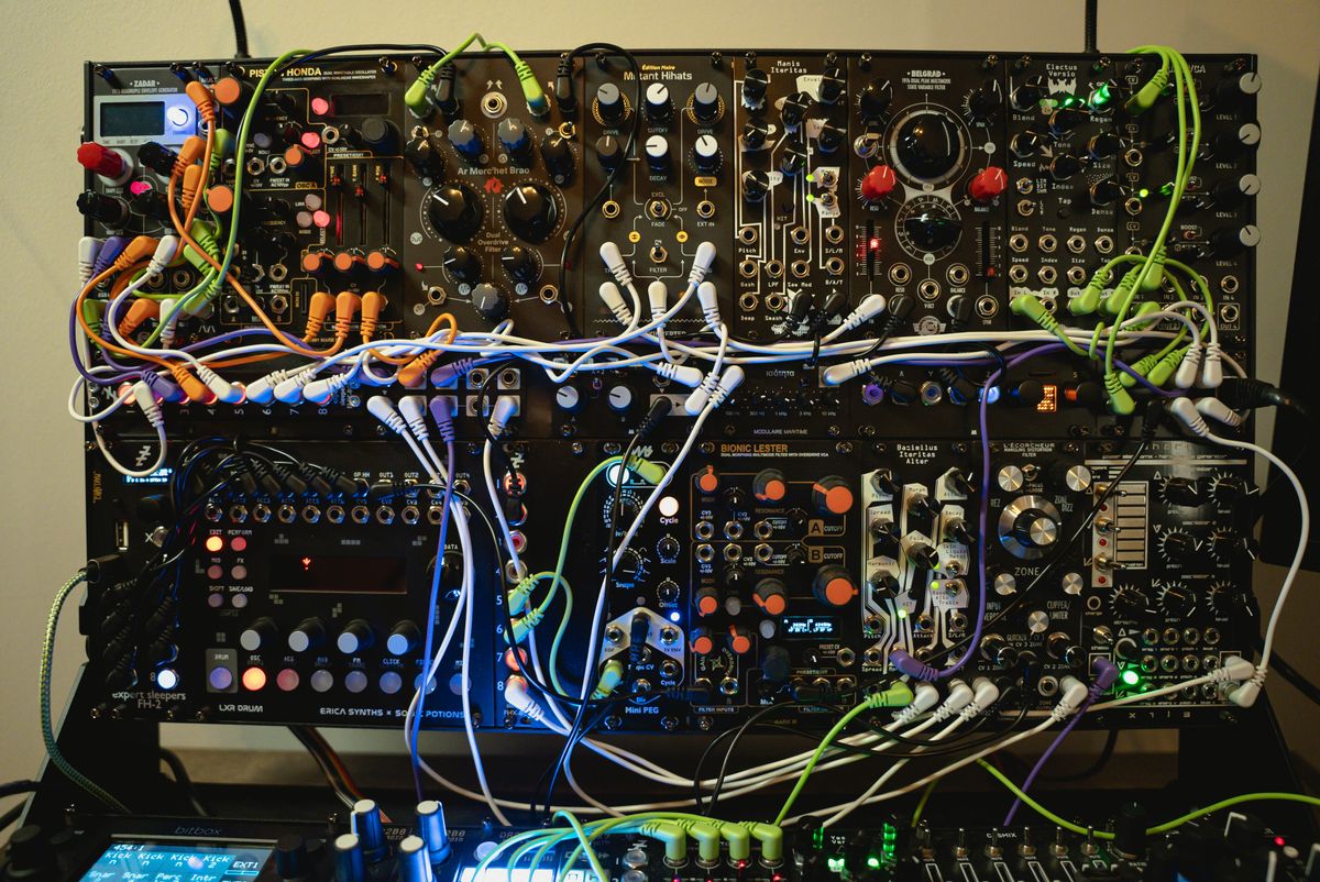 The upper rows of Krista's modular case filled with synthesizer modules and colorful patch cables