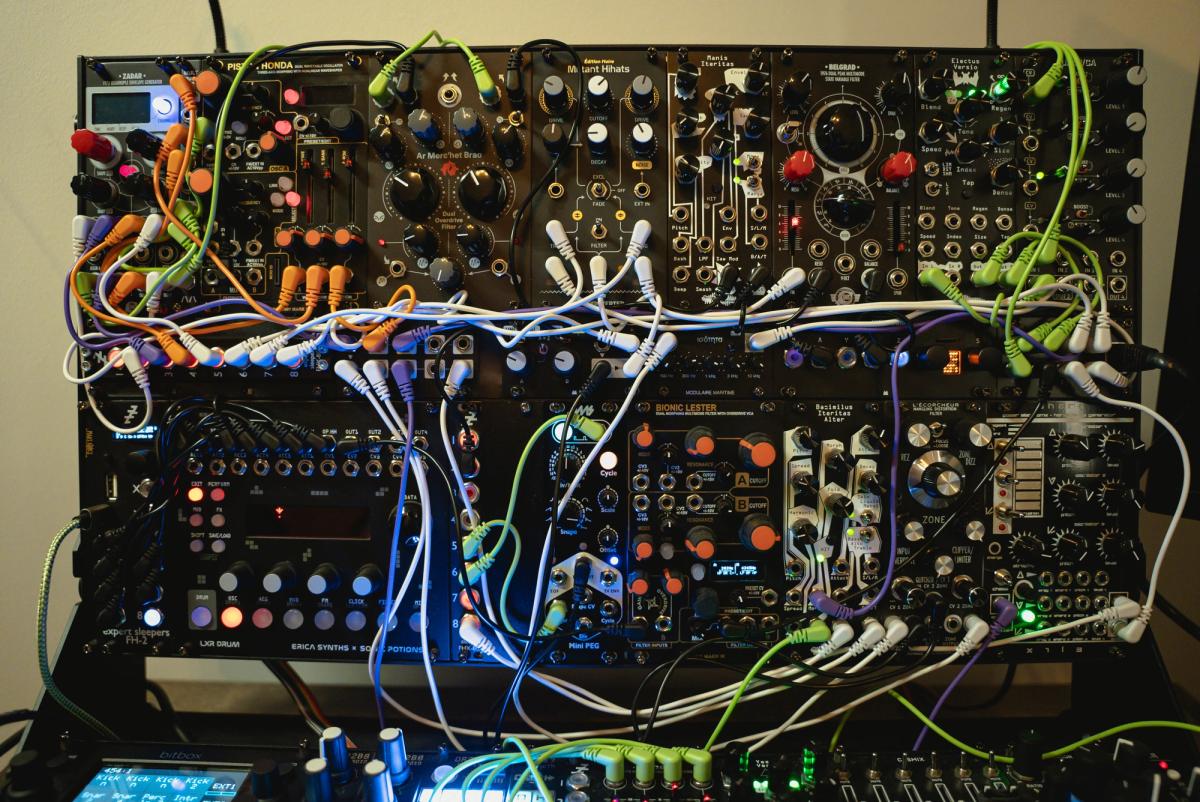 The upper rows of Krista's modular case filled with synthesizer modules and colorful patch cables