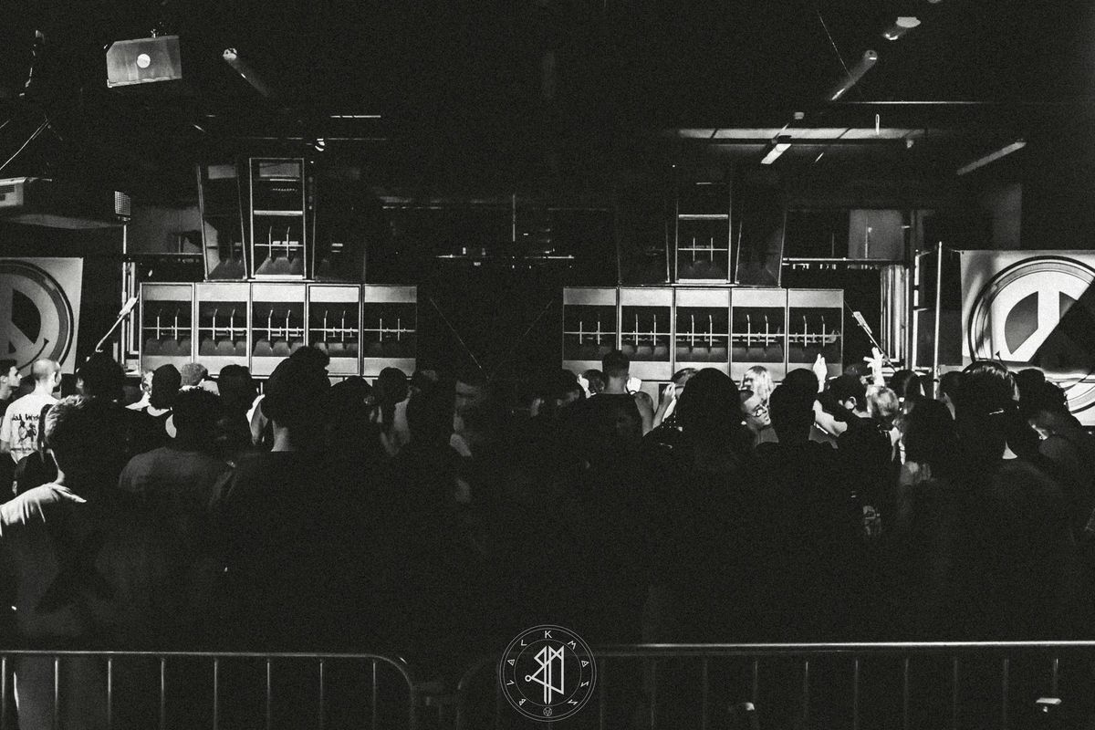 Black and white photograph of a crowded Black Mass dance floor facing the DJ booth