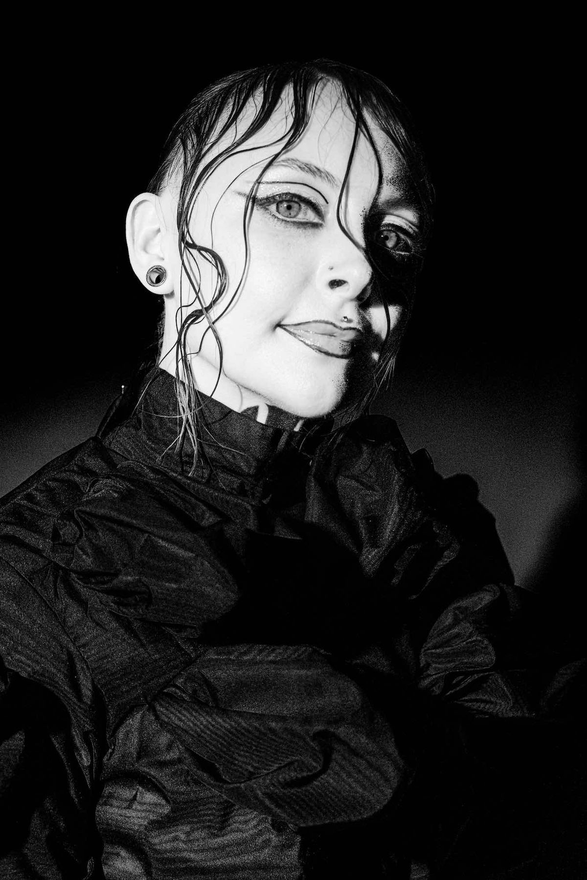 Black and white close-up of Krista tilting her head in a high-necked ruffled top