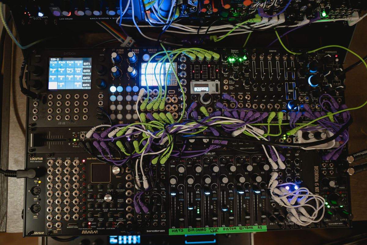 The lower section of Krista's modular case with mixer controls, illuminated screens and patch cables
