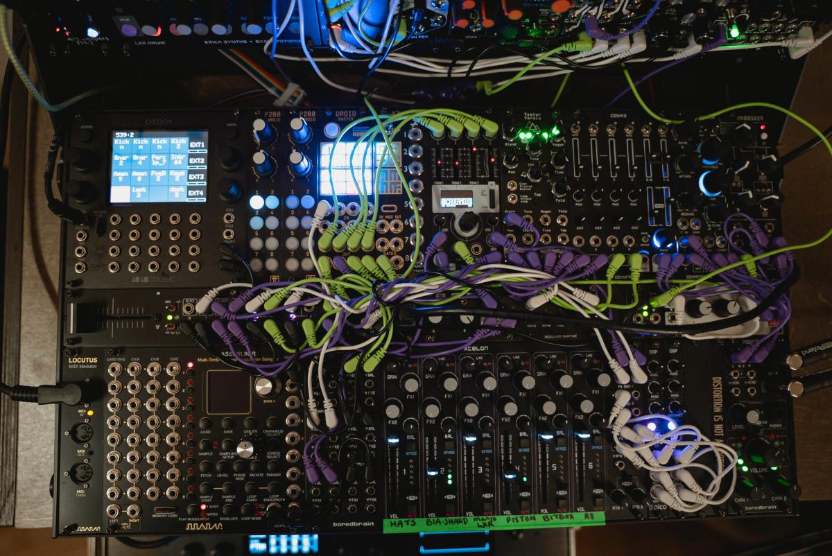 The lower section of Krista's modular case with mixer controls, illuminated screens and patch cables