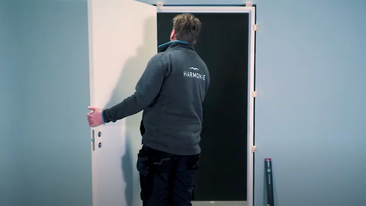 Mann som holder på å montere innerdør.