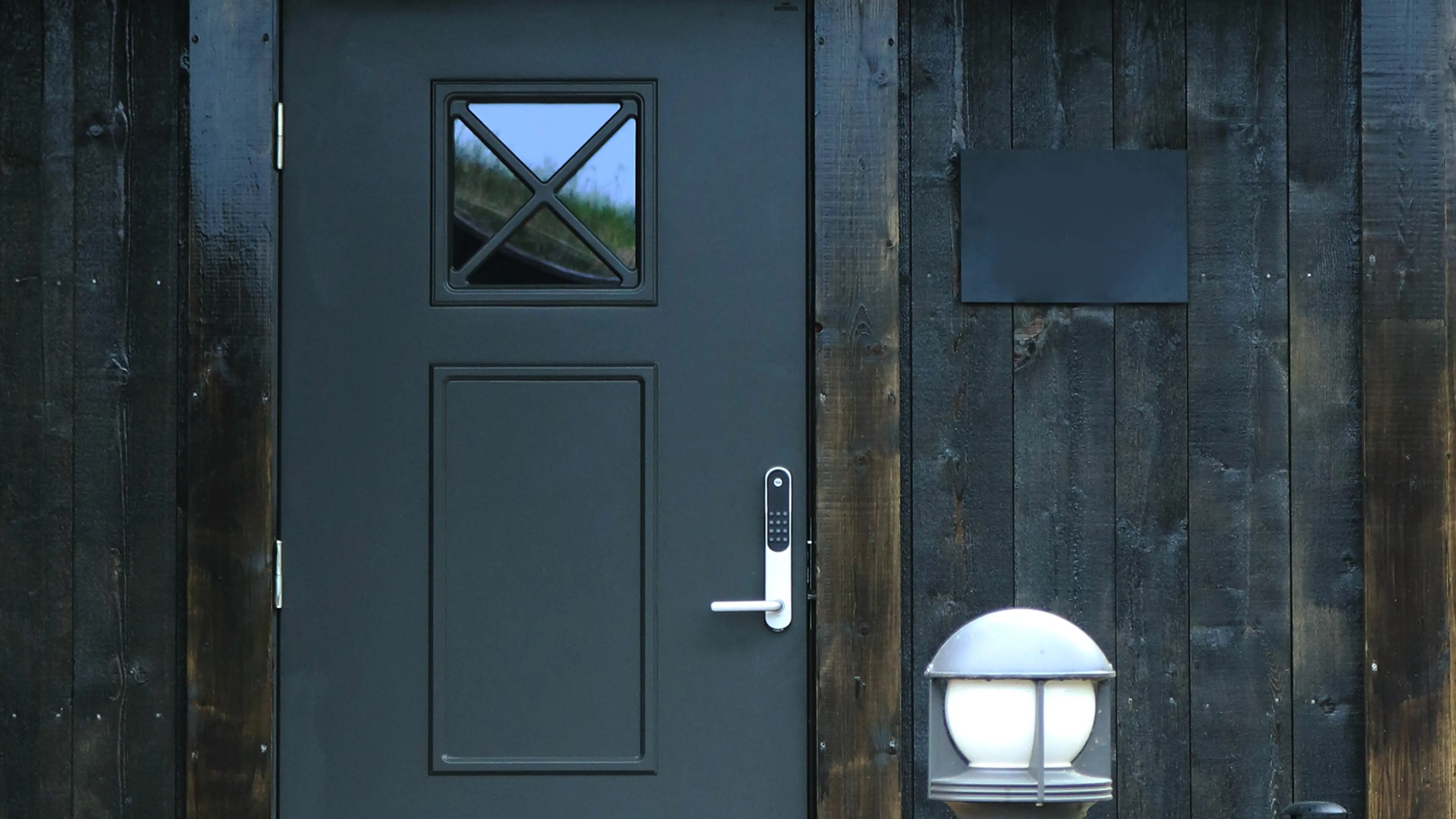 Sort hyttedør med glass.