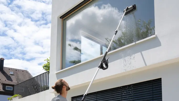 Mann som viser hvordan vaske vinduer ute som er høyt oppe.