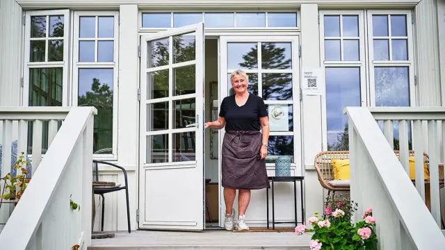 Kvinne er på vei ut av en klassisk dobbel verandadør med sprosser om våren.