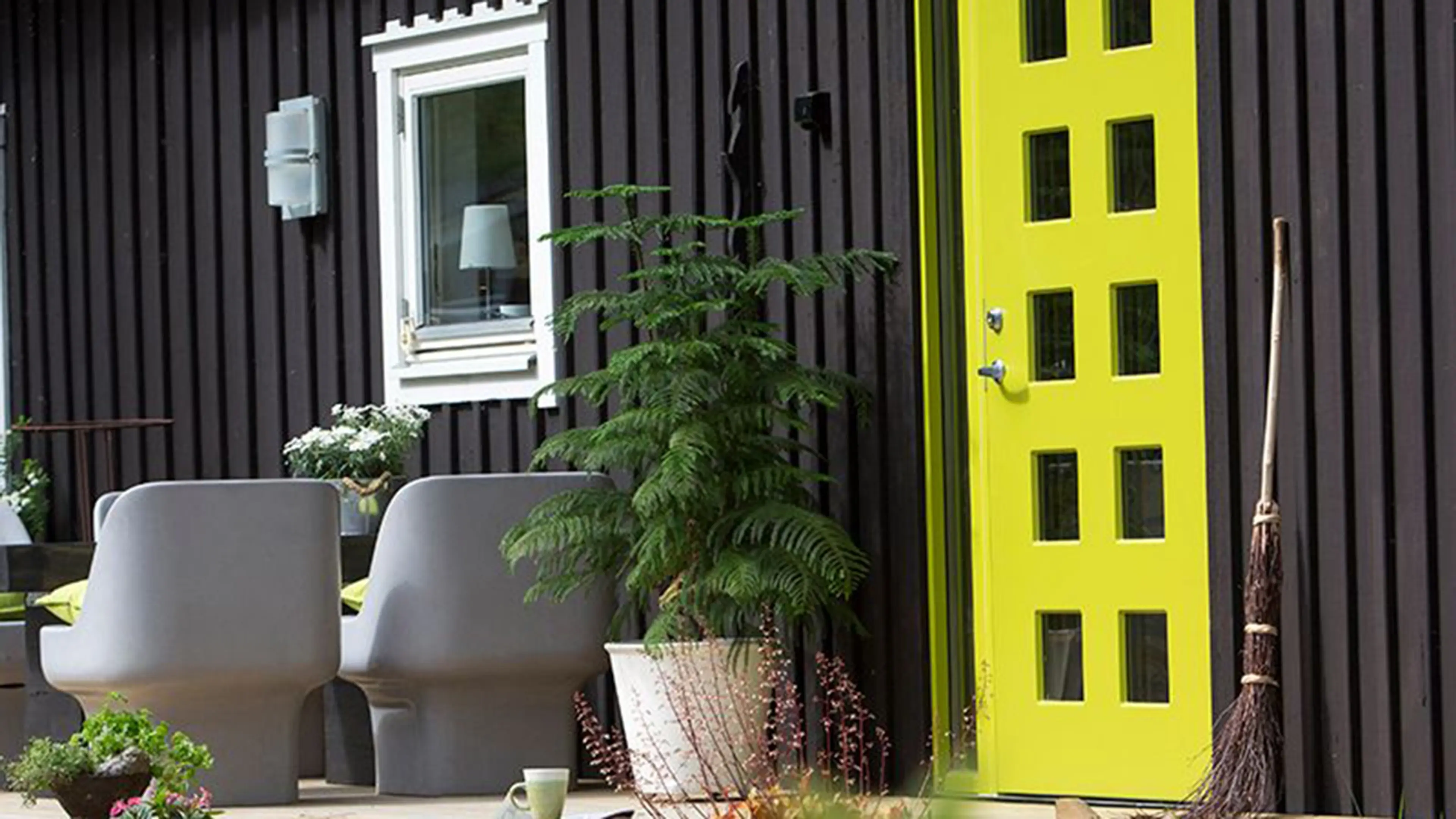 Svart hus med limegrønn ytterdør fra Swedoor.