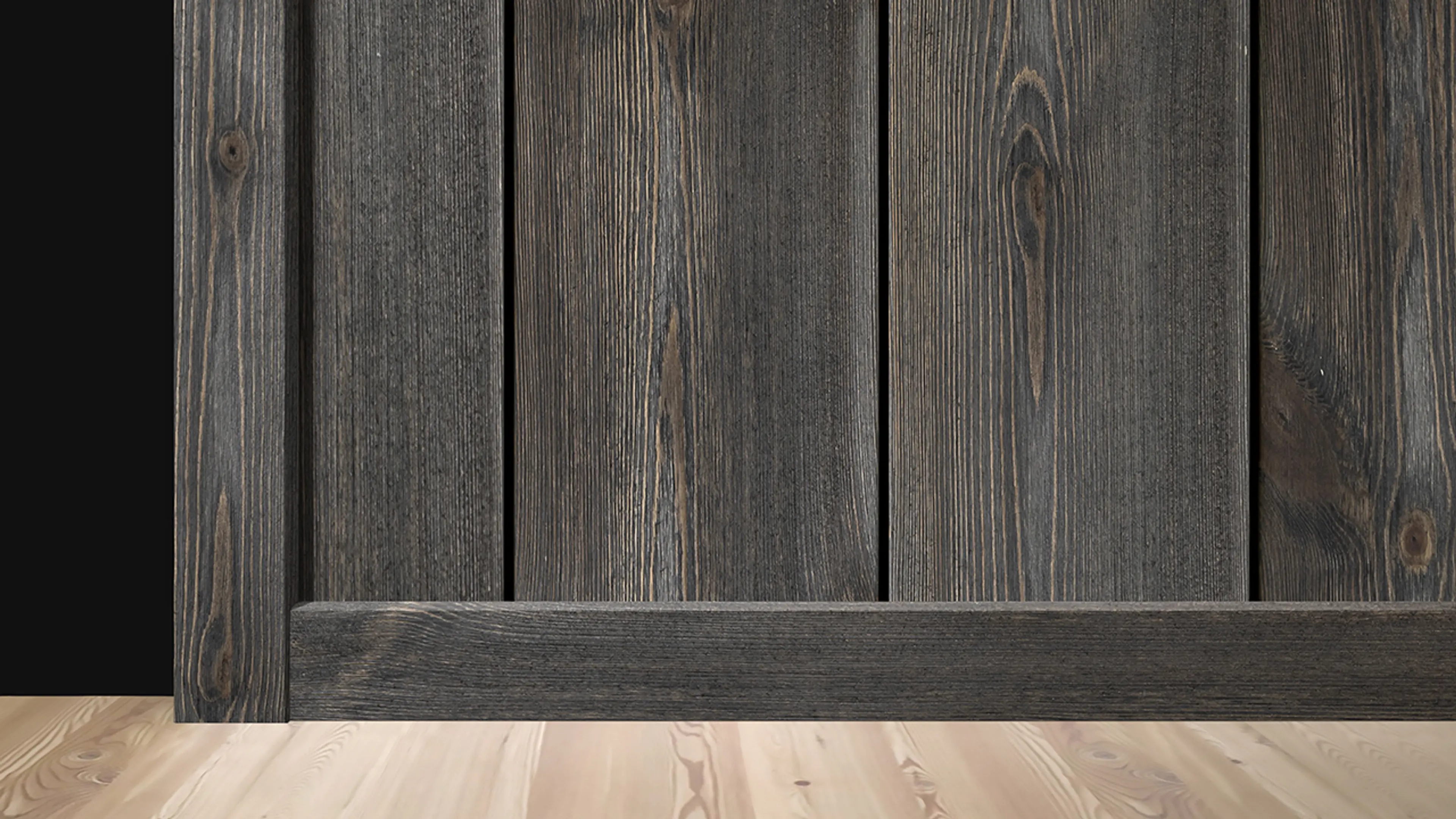 Nærbilde av vegg med trepanel og listverk i samme beisfarge.